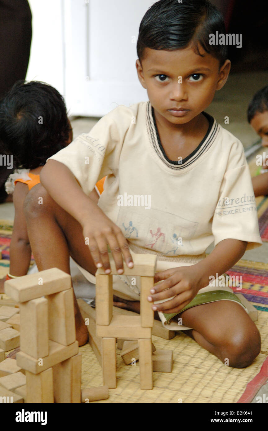 Jeune enfant dans l'un des nombreux bidonvilles de Chennai banlieue crèche ; Inde, Tamil Nadu, Chennai (Madras) ... Banque D'Images