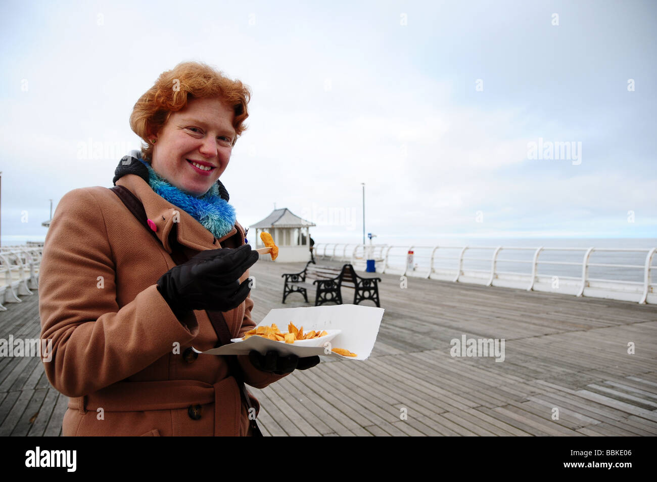 Woman Eating fish and chips à la mer, Cromer, Norfolk, Angleterre Banque D'Images