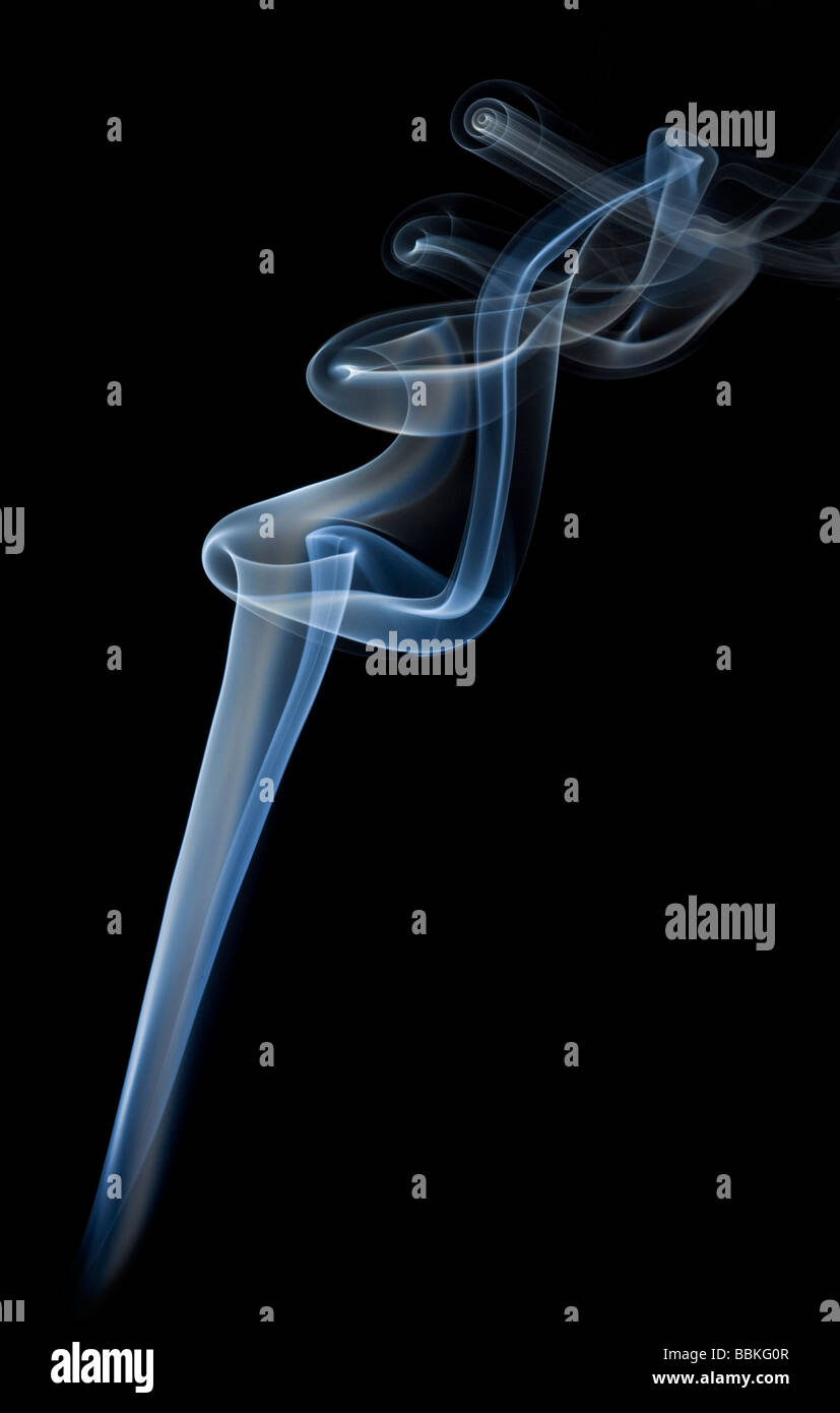 Les boucles de la fumée dégagée par la combustion lente d'un bâton d'encens.volutes de fumée dégagées par la combustion d'un bâton d'encens Banque D'Images