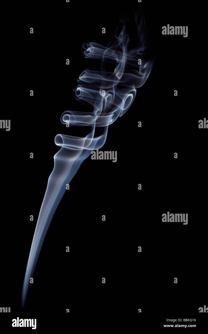 Les boucles de la fumée dégagée par la combustion lente d'un bâton d'encens.volutes de fumée dégagées par la combustion d'un bâton d'encens Banque D'Images