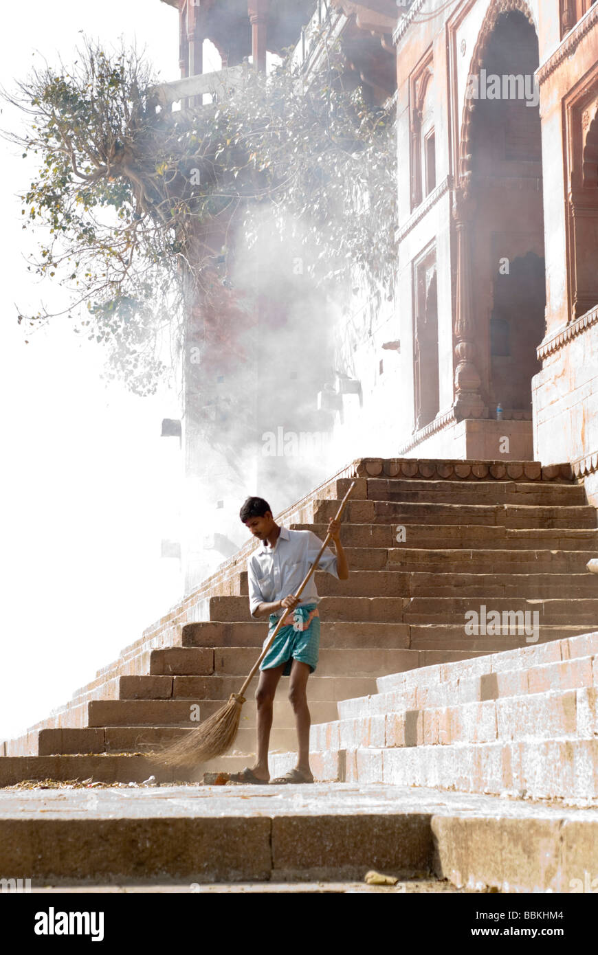 L'homme de basse caste balayer une echelle ghat de Varanasi, Inde. Banque D'Images