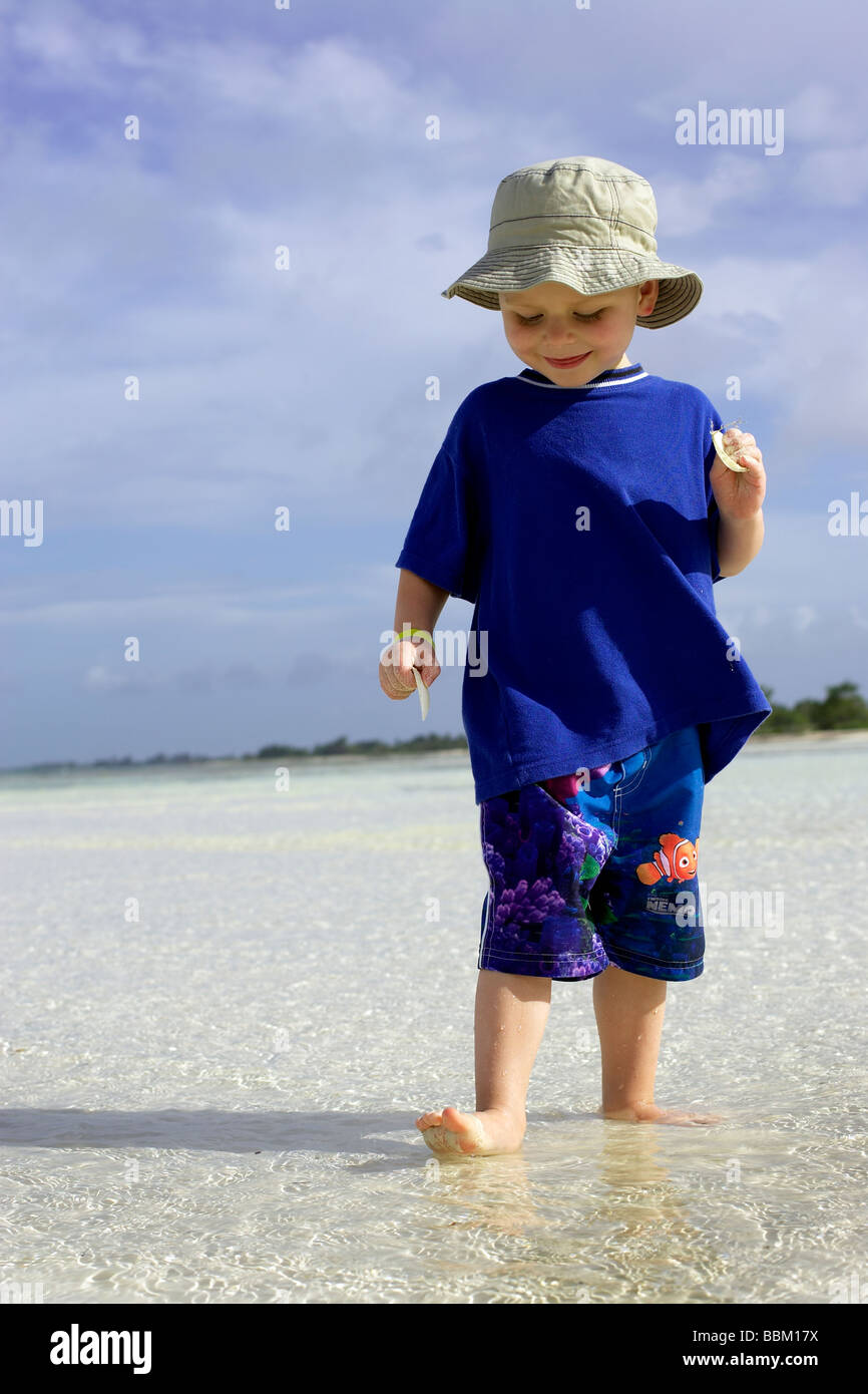 Garçon debout dans l'eau peu profonde, sur la plage, CamagÃƒÂ¼ey, Cuba Banque D'Images