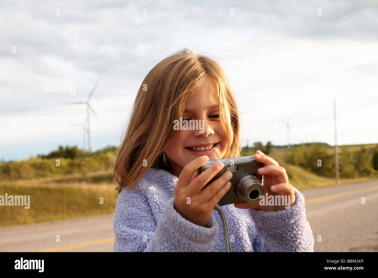 Girl looking at digital camera en face des éoliennes, Tiverton, péninsule Bruce, en Ontario Banque D'Images