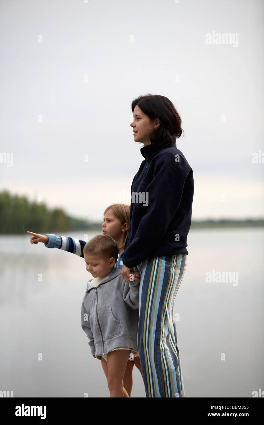 Maman, fille, fils debout près d'un lac Banque D'Images