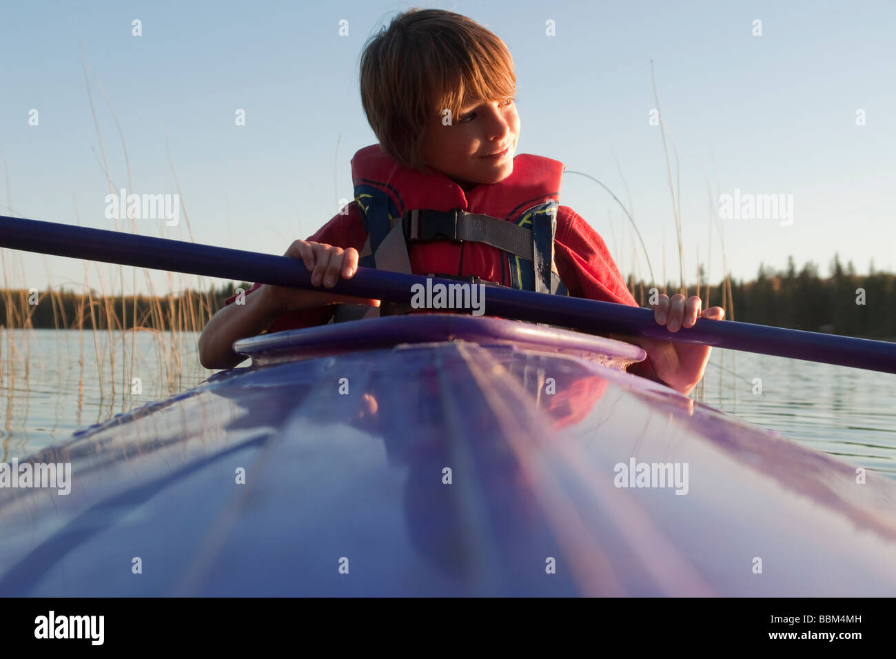 10 ans en kayak regarde vers le coucher du soleil, le lac Katherine, Parc national du Mont-Riding, Manitoba Banque D'Images