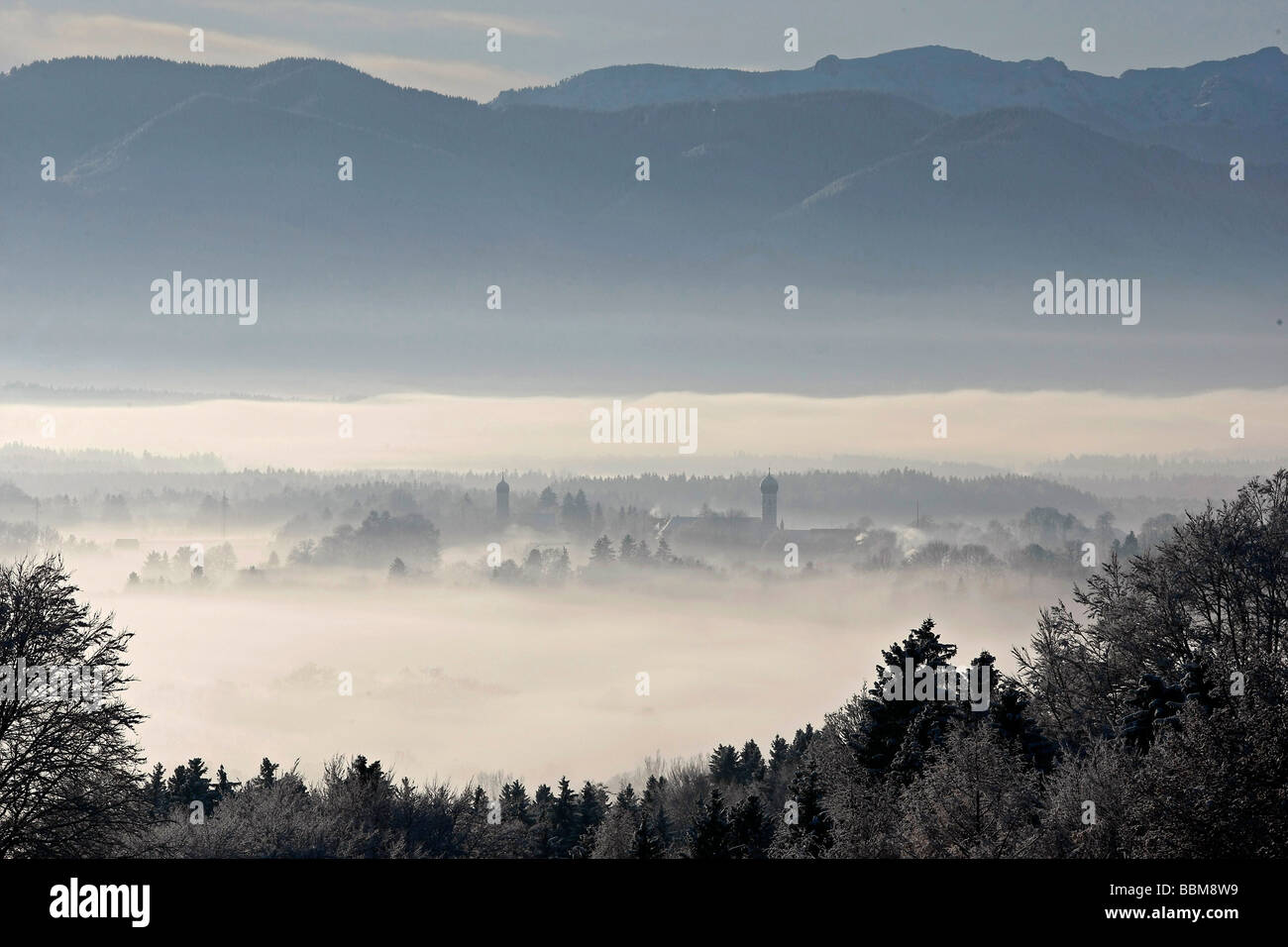 Vue depuis la vallée de la montagne Schlossberg Loisachtal, impressions hivernales avec les deux tours d'église de Saint Pierre, un Breuerberg Banque D'Images