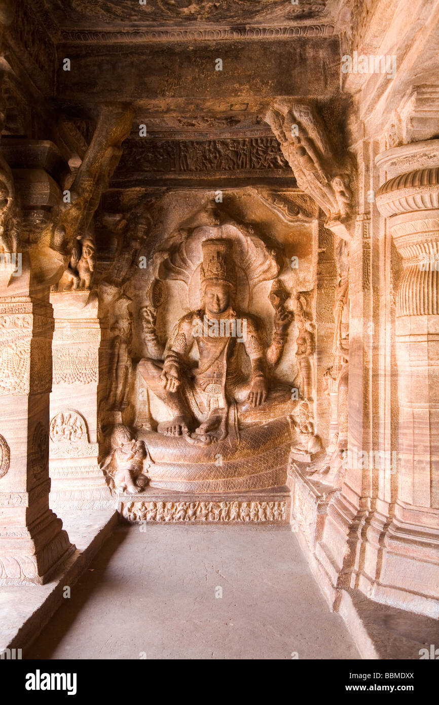 La figure de pierre sculpté de Vishnu assis sur un serpent enroulé dans les grottes de Badami, Karnataka, Inde Banque D'Images