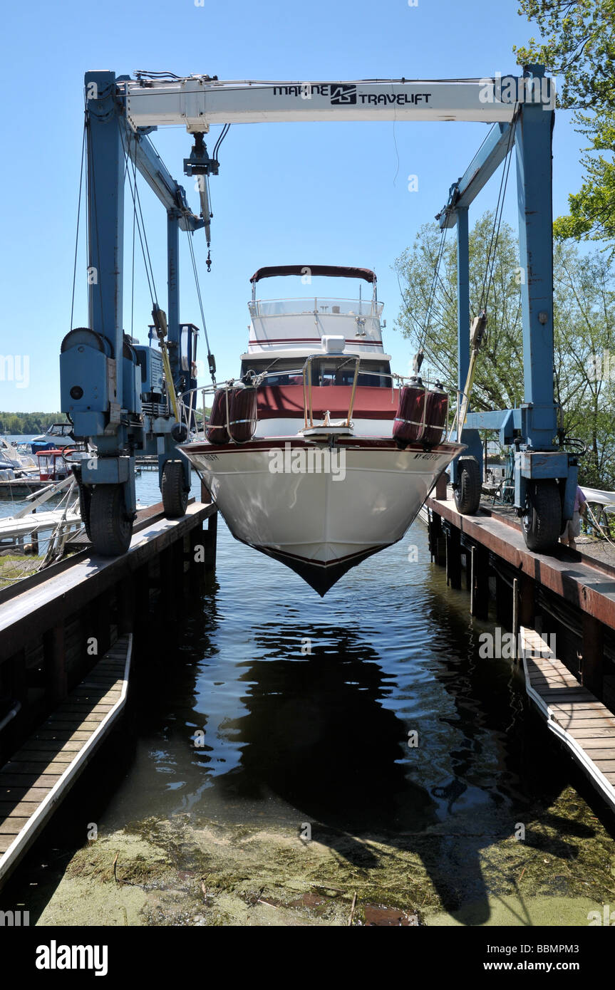 Luxury cabin cruiser dans l'élingue de chargement, étant descendu dans l'eau. Banque D'Images