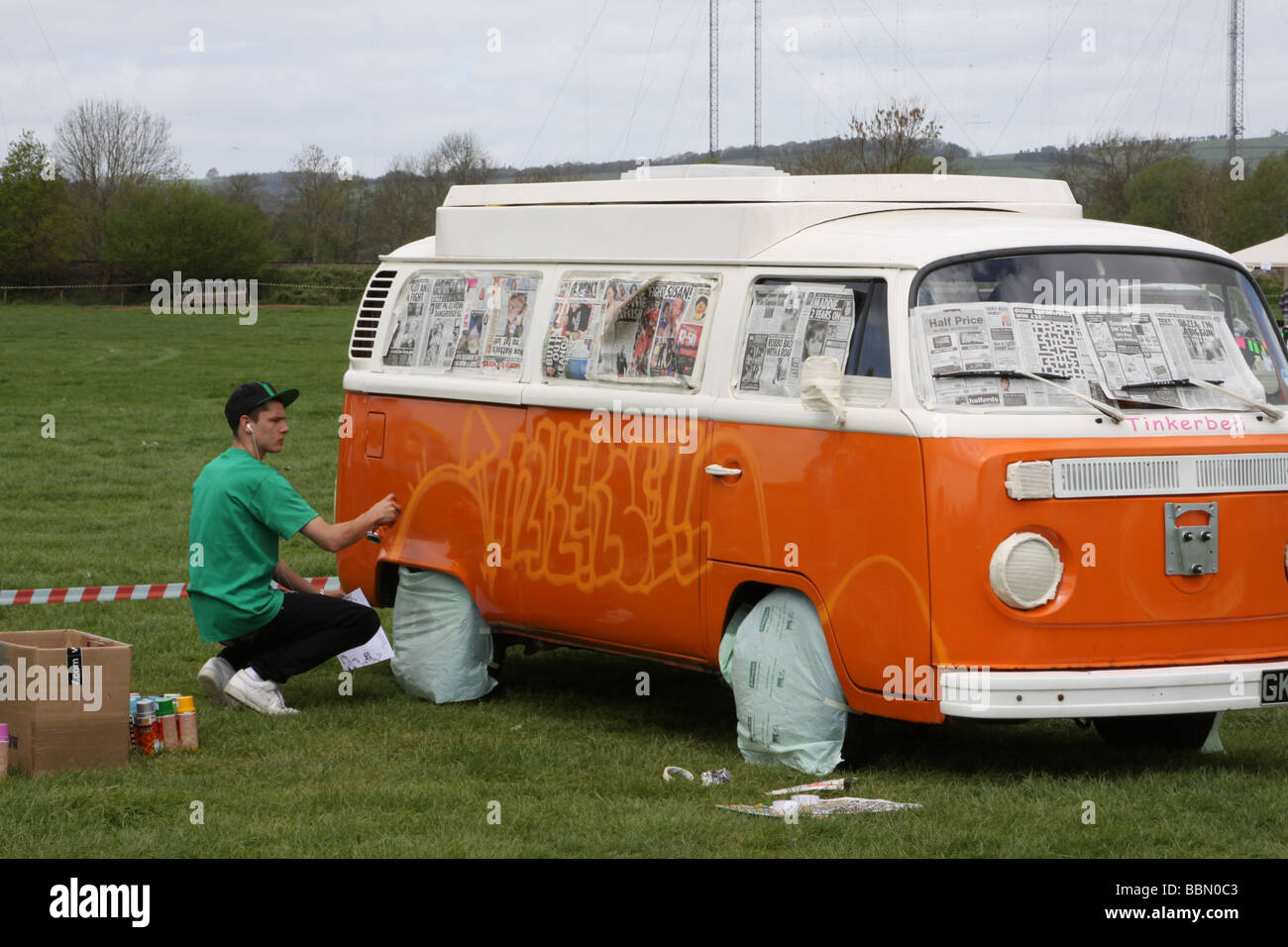 Orange et Blanc VW camper van étant pulvérisée avec graffiti Photo Stock -  Alamy