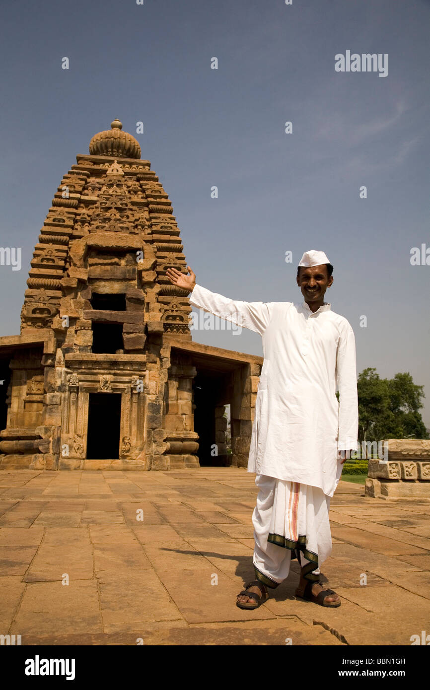 Un guide habillé en coton blanc et le dhoti kapi, le costume local d'Amérique du Karnataka, montre un temple à Pattadakal. Banque D'Images