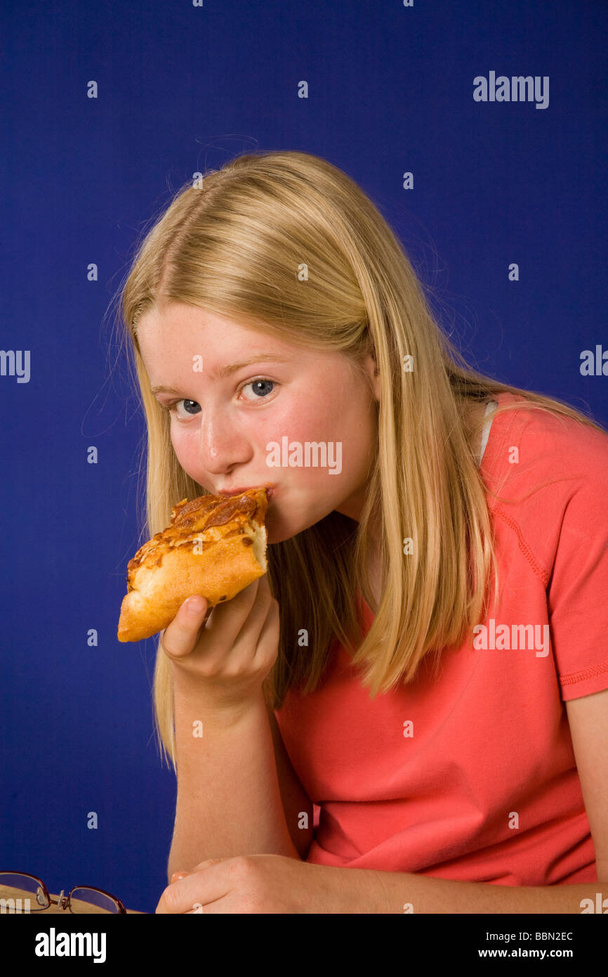 Portrait of Girl eating Tranche de pizza, studio shot cut out MR © Myrleen Pearson Banque D'Images