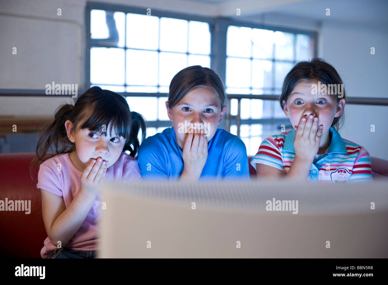 Trois petites filles secrètement regarder une vidéo Banque D'Images