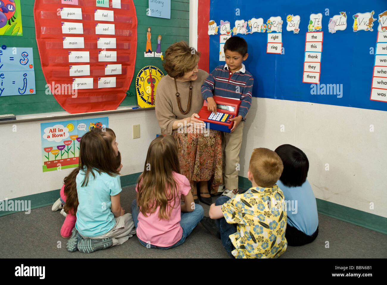 Les enfants du groupe scolaire élémentaire séance tapis chambre classe raciale ethnique interracial multiculturel retour voir les élèves de maternelle © Myrleen chefs M. Pearson Banque D'Images