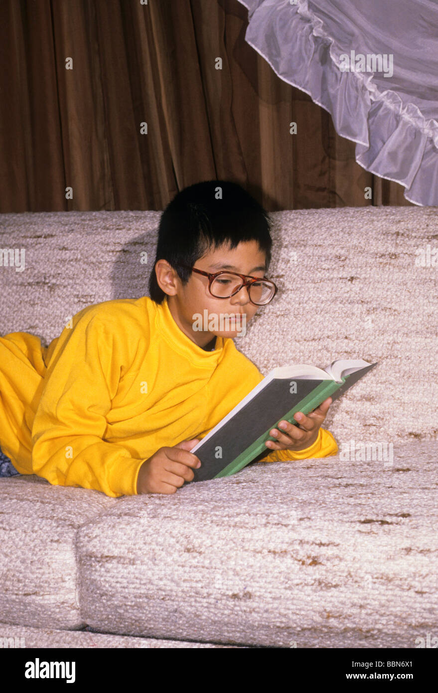 Korean-garçon américain read book devoirs étude intention de verre se concentrer sérieusement attention engross Banque D'Images