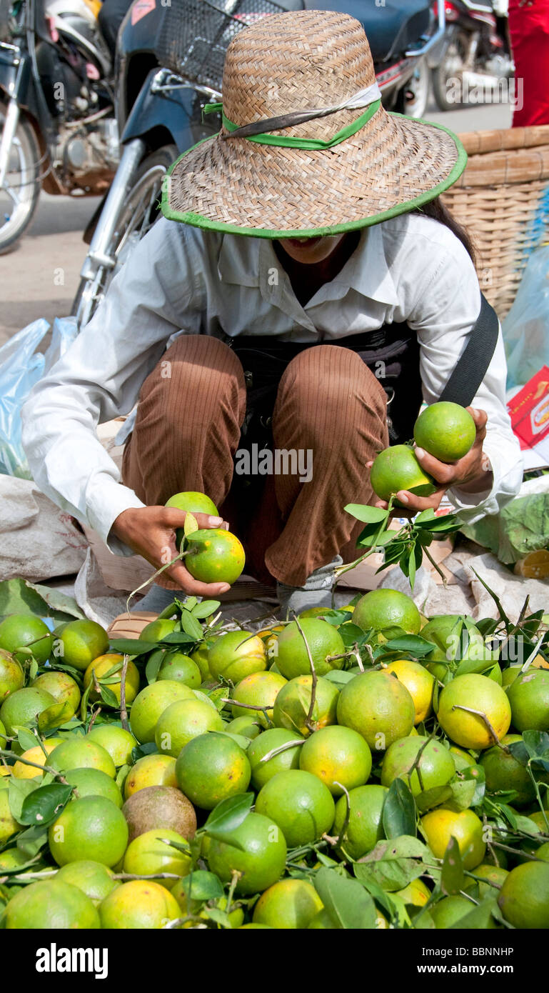 Achat femme limes dans un marché à Battambang, Cambodge Banque D'Images