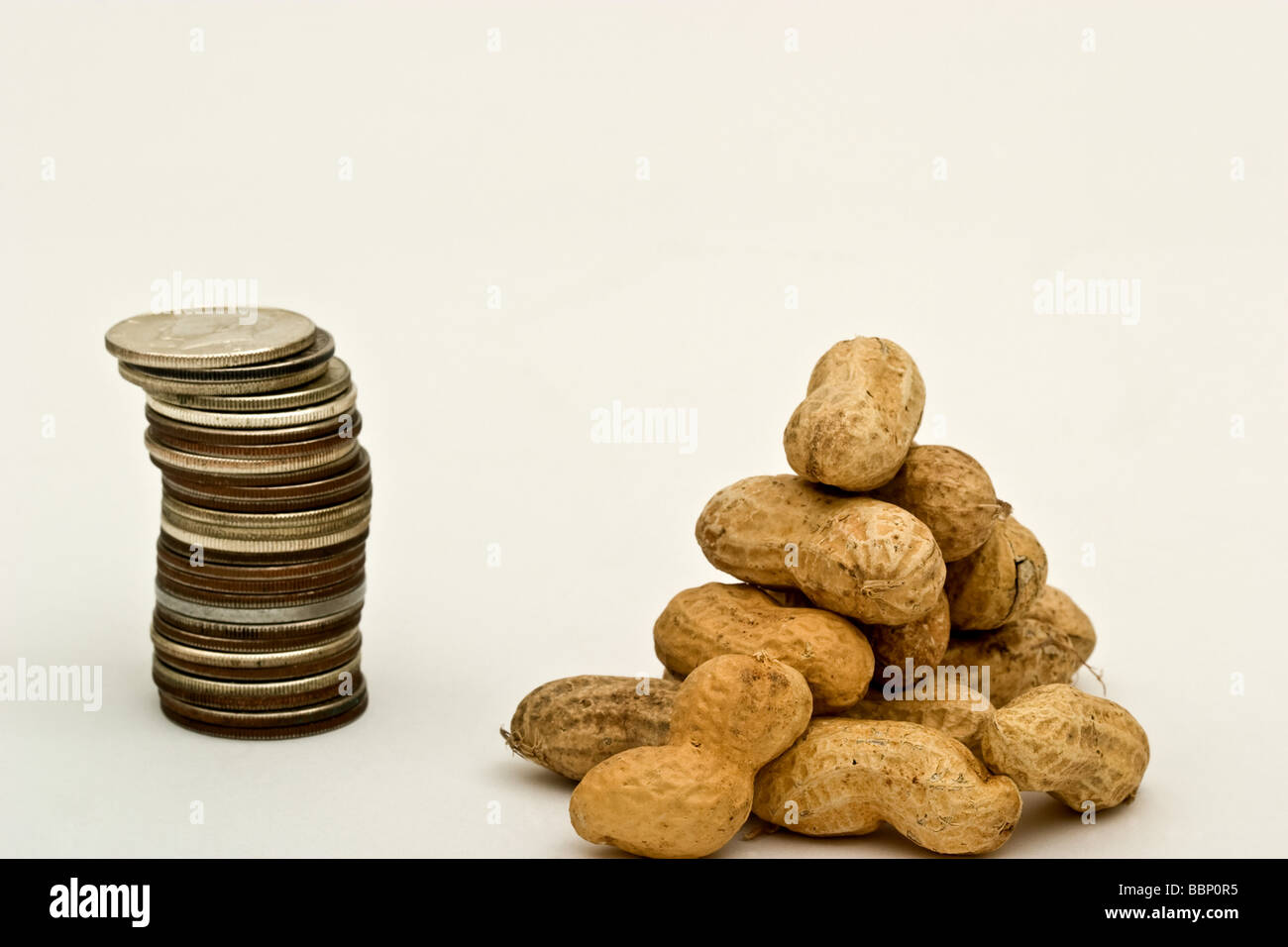 Pile de pièces en demi-dollar américain à côté d'un tas d'arachides Banque D'Images