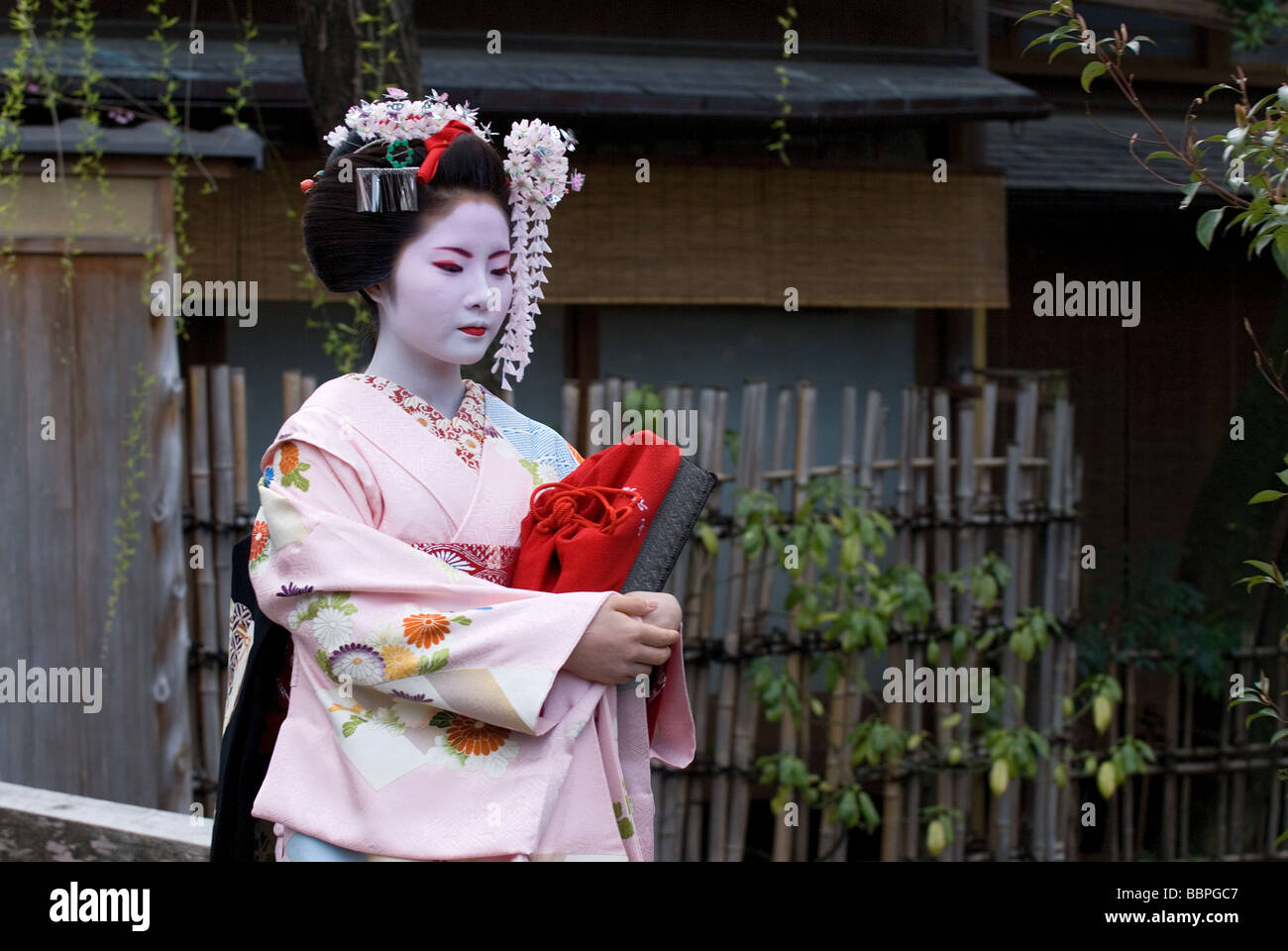 Une apprentie geisha, ou maiko, marchant le long d'une rue dans le quartier de Shimbashi Kyoto Gion. Banque D'Images