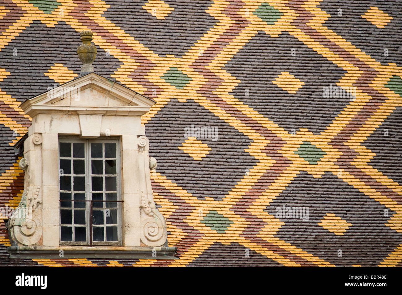 Vitrage à motifs traditionnels des tuiles colorées et lucarne à l'Hôtel-Dieu, Hospices de Beaune en Bourgogne, France Banque D'Images