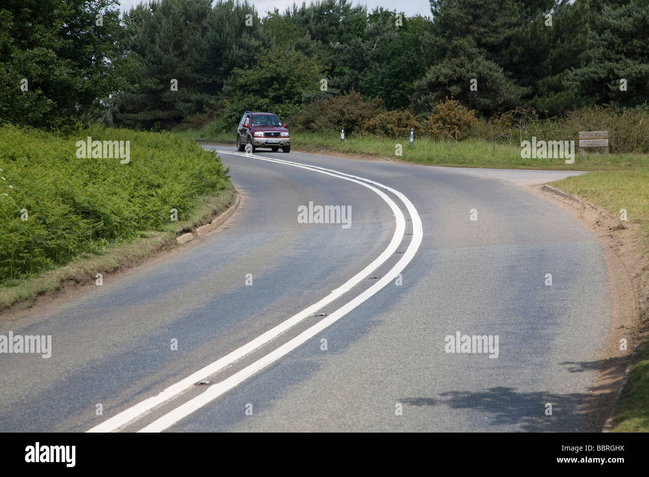 Virage à gauche a bend de route avec double white lines Banque D'Images