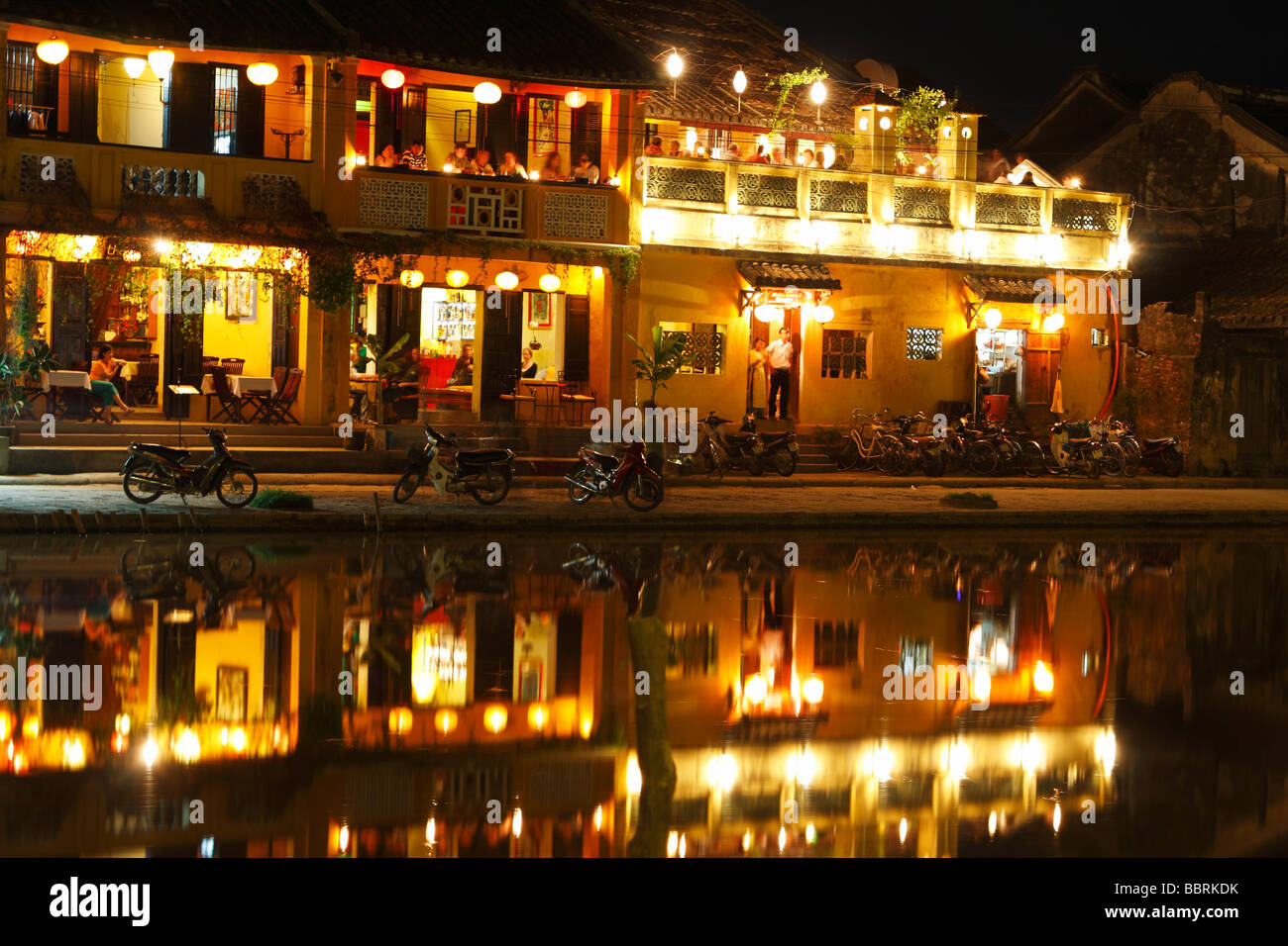 "Hoi An riverside' restaurants de nuit, feux de bâtiment colonial reflète dans l'eau de la rivière Thu Bon ', Vietnam Banque D'Images