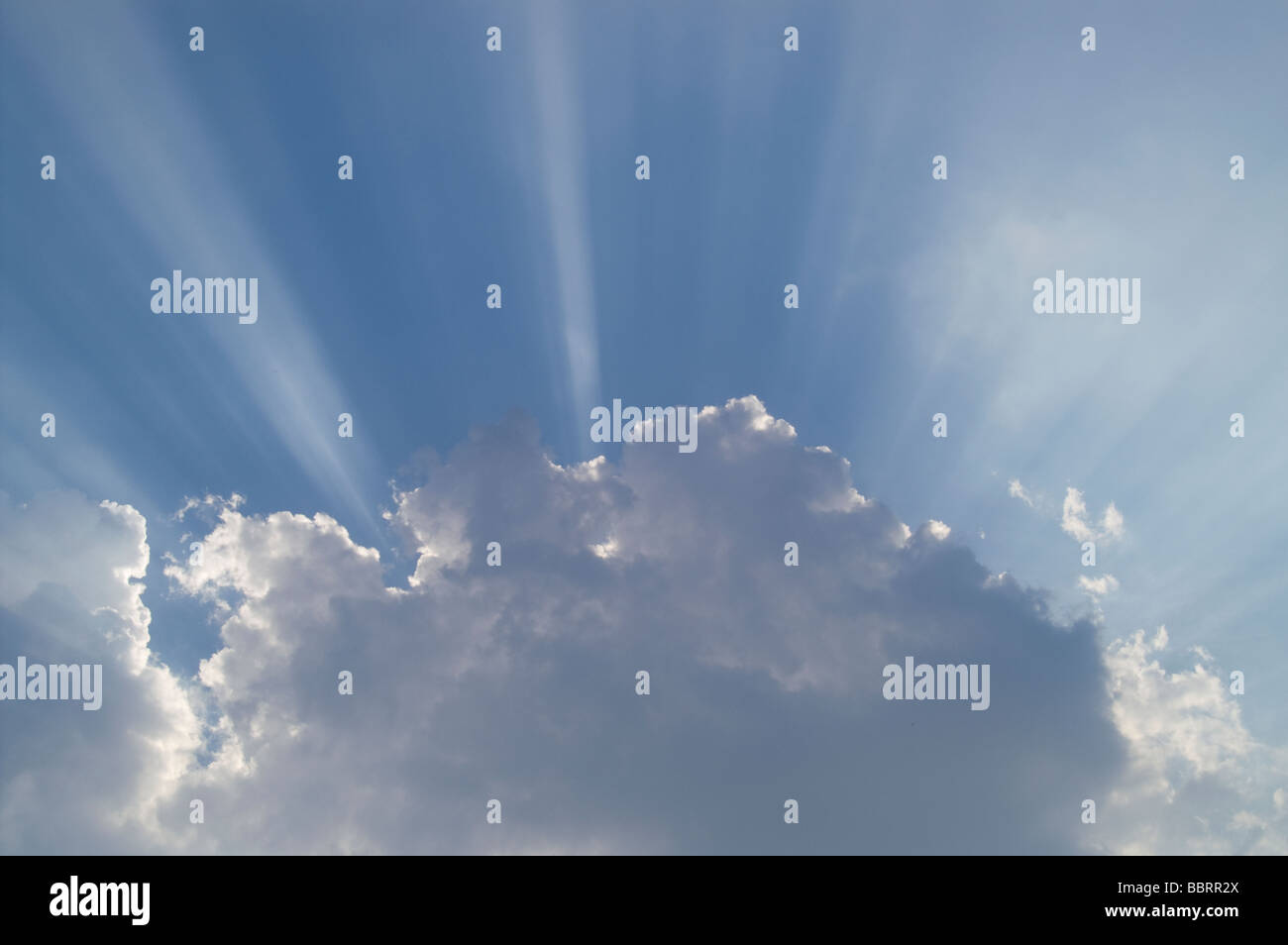 Puits de lumière filant à travers les nuages blancs sur un ciel bleu Banque D'Images