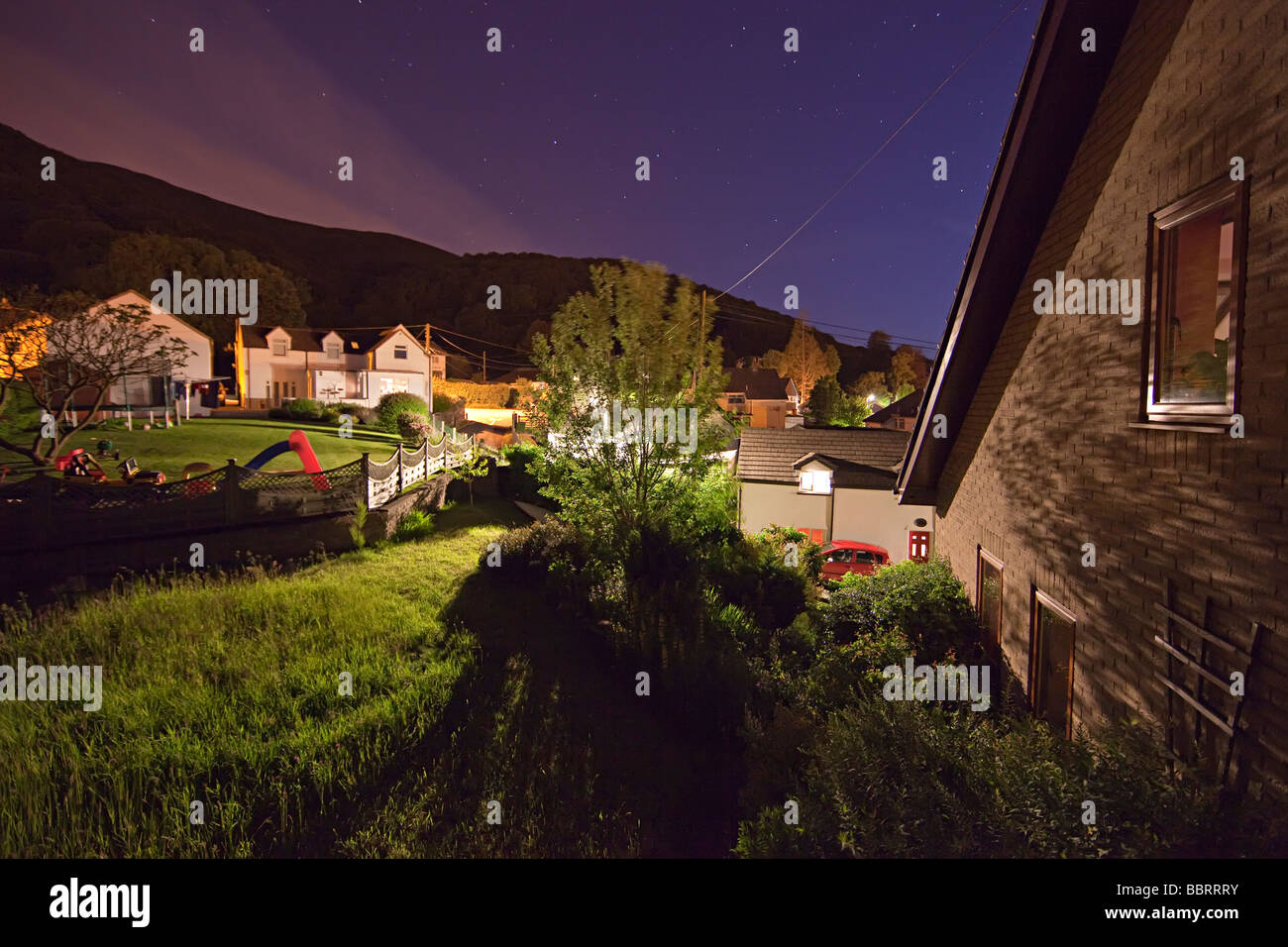 Maison jardin et bâtiments dans le village de nuit avec la lumière d'un lampadaire Llanfoist Wales UK Banque D'Images