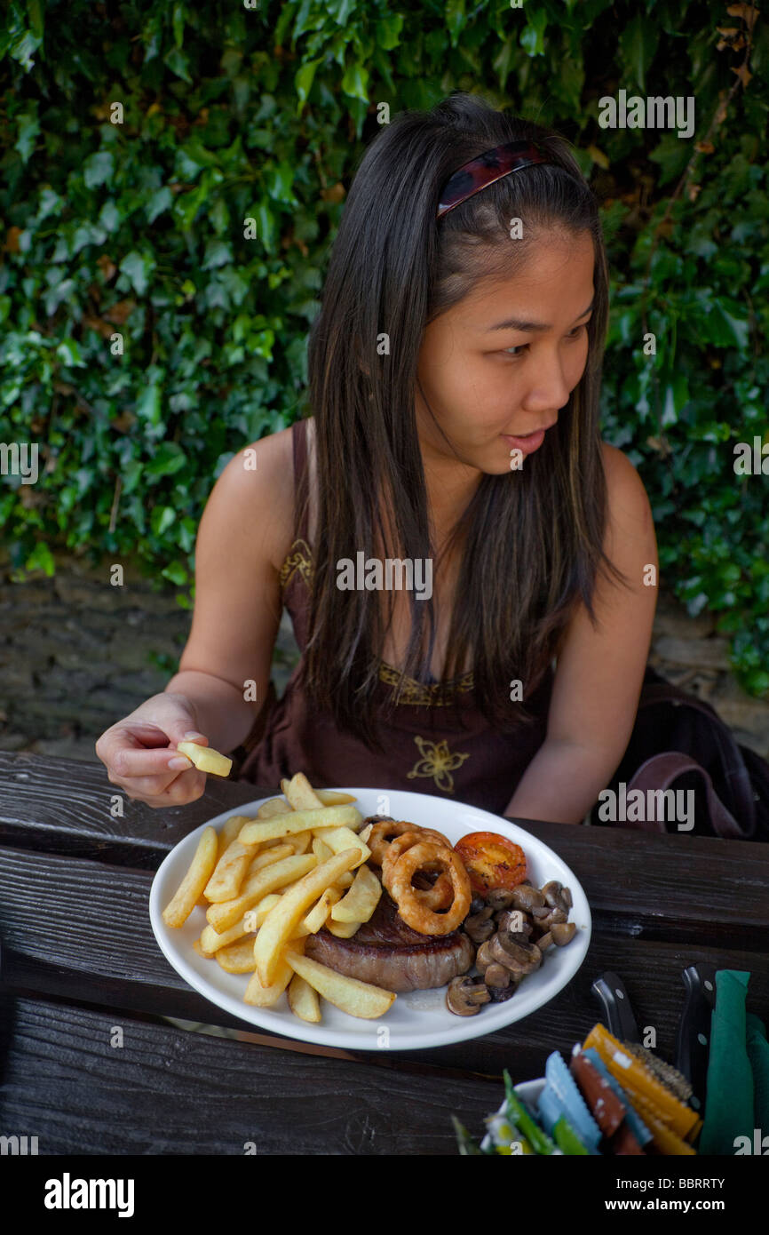 Tourisme Oriental dame trys son premier Western steak-frites meal Banque D'Images