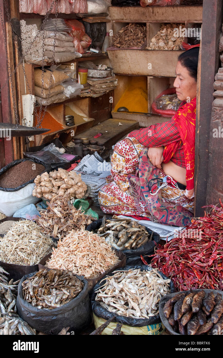 Katmandou, Népal. Un vendeur de poisson séché, les poivrons, le gingembre, et le riz vous attend les clients dans le marché de la Place Durbar. Banque D'Images