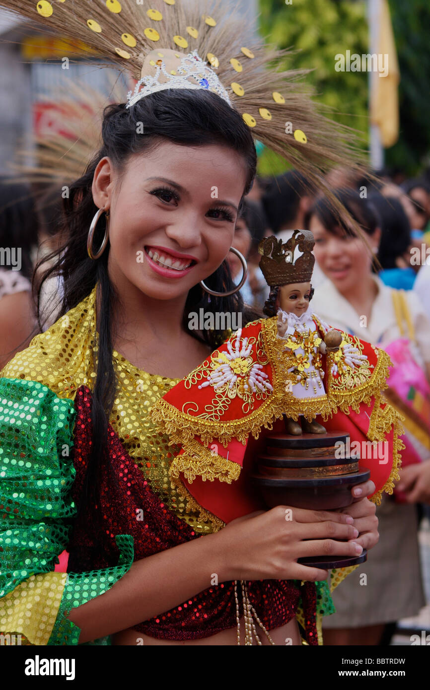 Femme avec un costume et sinulog Santo Niño poupée sur le sinulog festival Banque D'Images