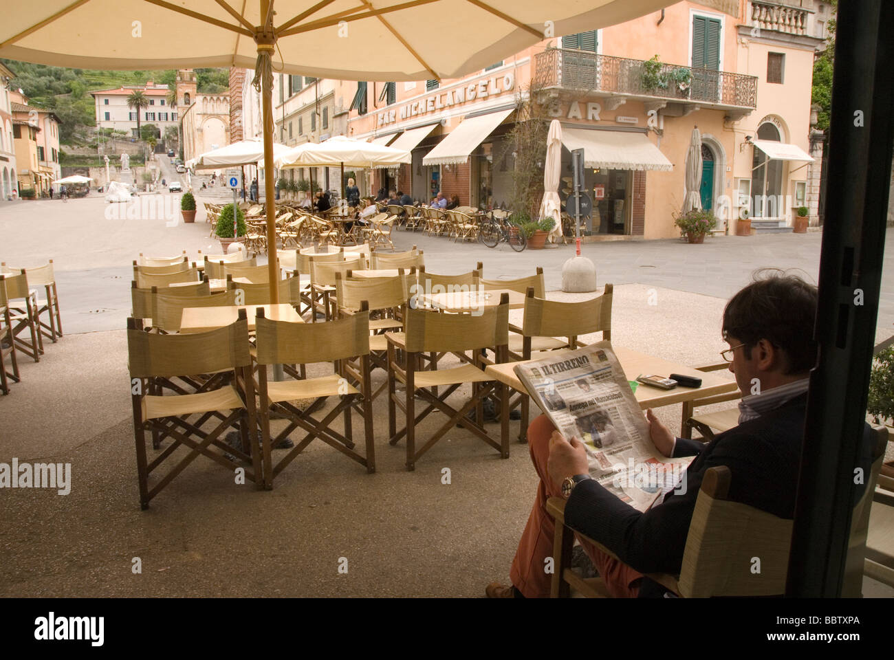 Un homme lit le journal local 'il Terreno' dans un bar à Pietrasanta, Toscane MS Banque D'Images