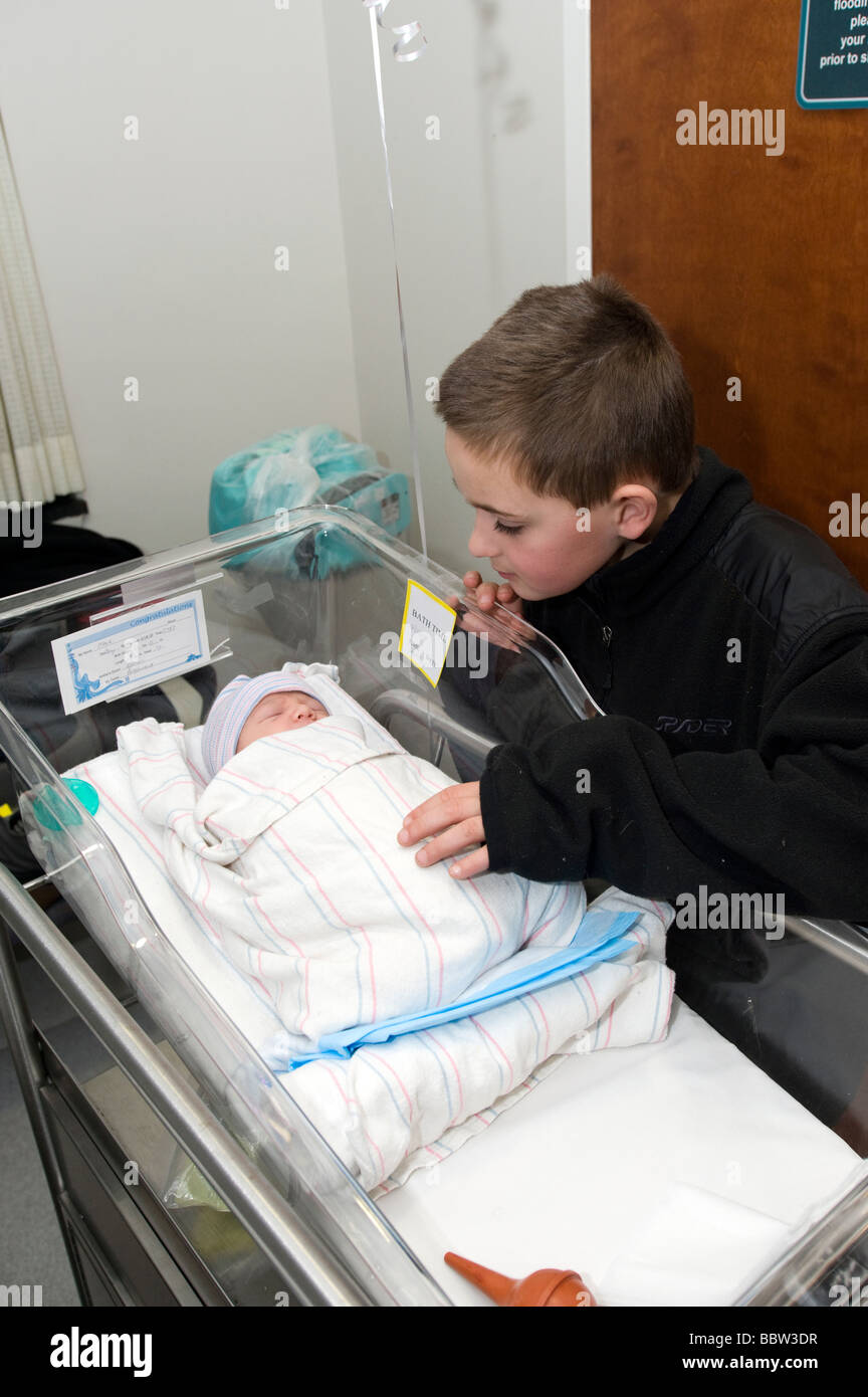 Garçon de dix ans voit son cousin nouveau-né, le plus récent ajout à la famille, à l'hôpital local Banque D'Images