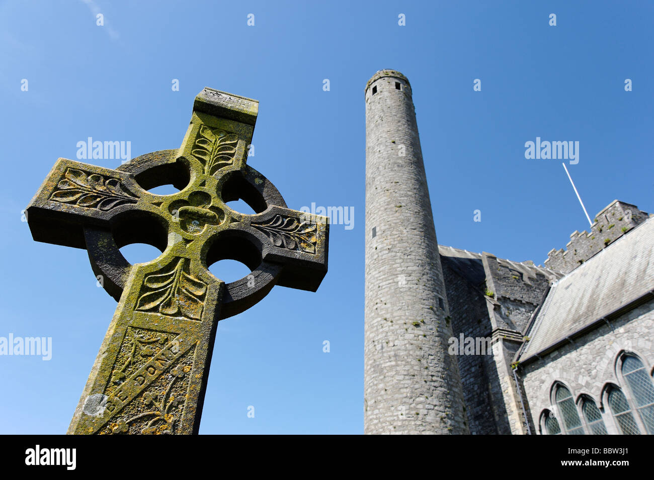 Croix celtique en face de la cathédrale Saint Canices et tour dans la ville de Kilkenny Irlande du Sud Banque D'Images