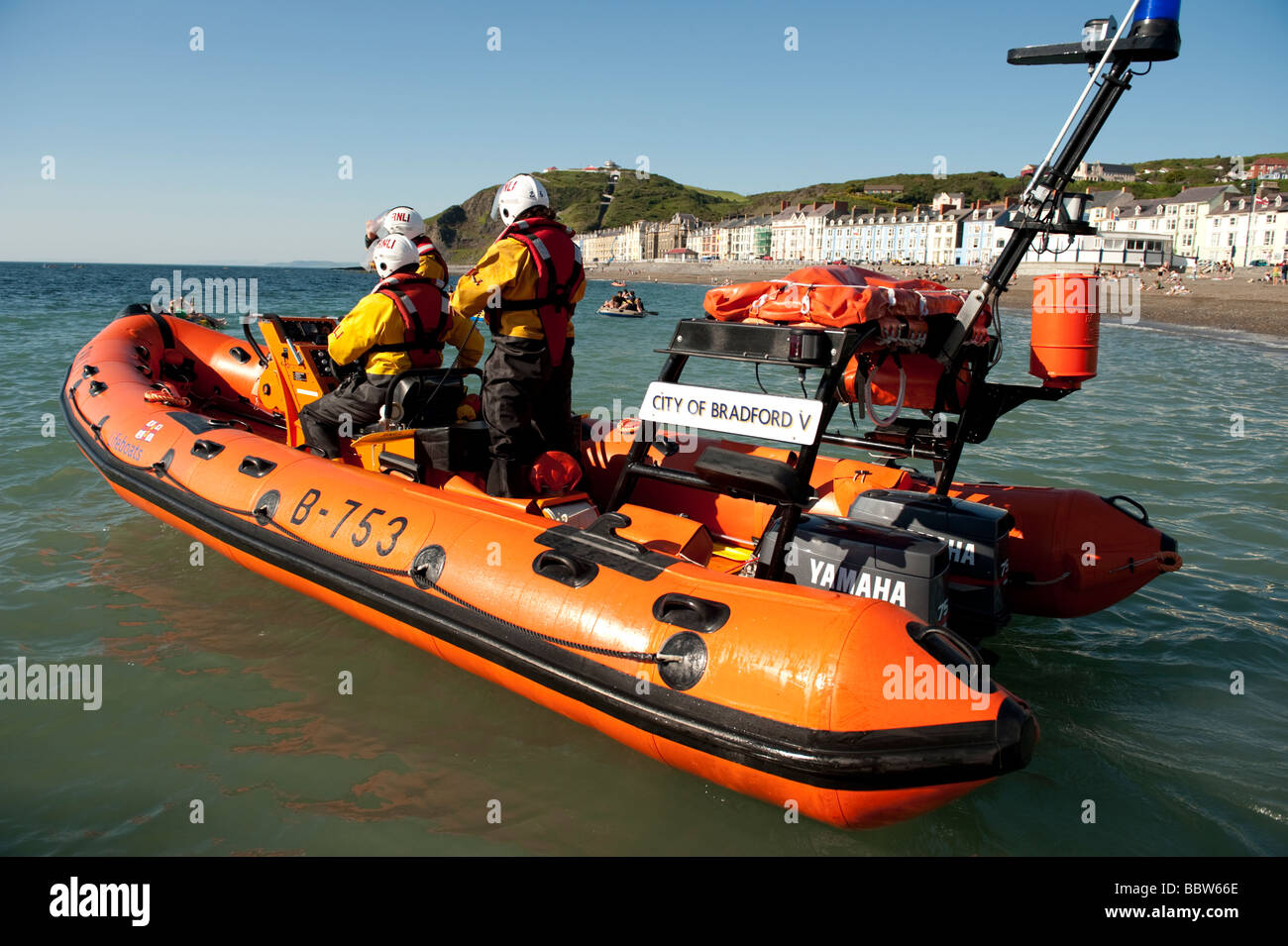 Contrôle de l'embarcation de sauvetage côtier de la RNLI sur les étudiants qui avaient dérivé sur la mer sur l'annexe gonflable Wales UK Banque D'Images