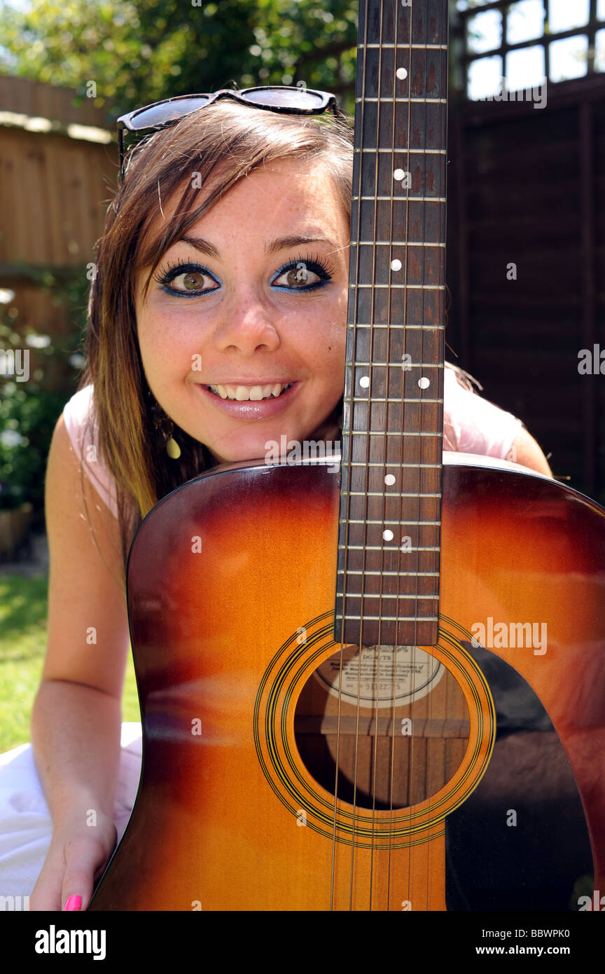 Femme séduisante jeune femme avec Fender guitare acoustique dans le jardin  aux beaux jours Photo Stock - Alamy
