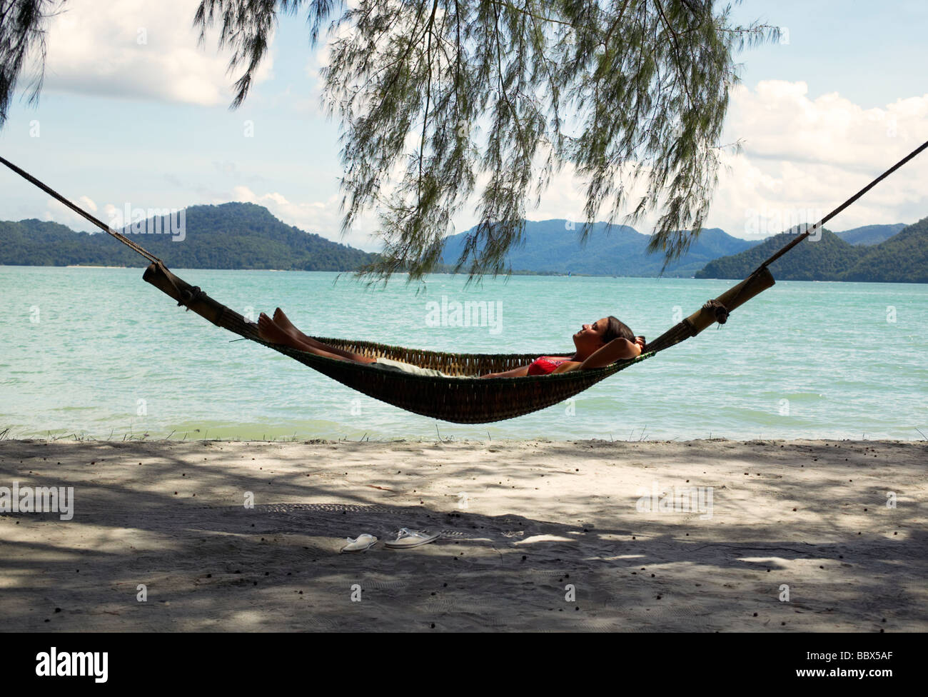 Femme dans un hamac sur la plage de la Malaisie. Banque D'Images