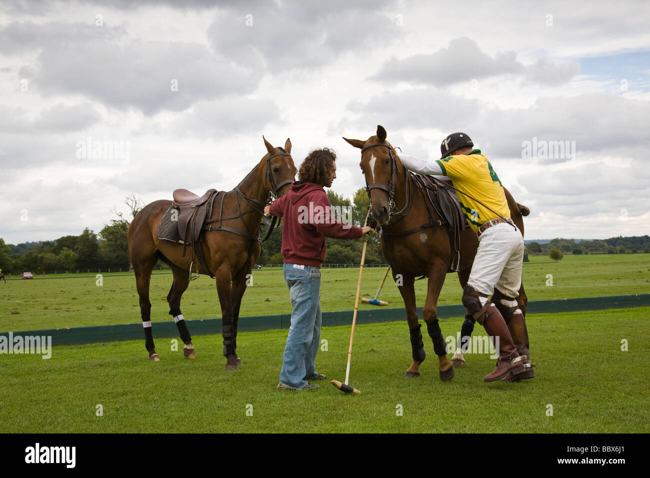 Un joueur de polo chevaux changements au milieu chukka Cowdray Park, West Sussex, Angleterre. Banque D'Images