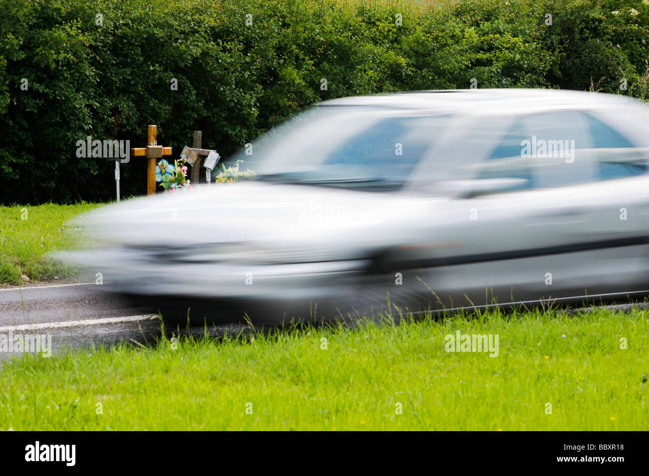 La vitesse d'une voiture au-delà d'un road-SIDE MEMORIAL, LE MARQUAGE D'UN PRÉCÉDENT ACCIDENT MORTEL. Près de Chesham, Buckinghamshire Banque D'Images