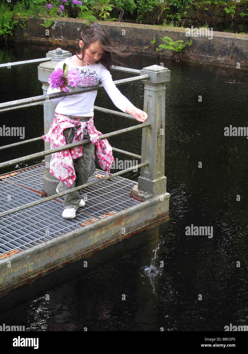 Enfant, à lancer de monnaie dans l'eau pour faire un voeu Banque D'Images