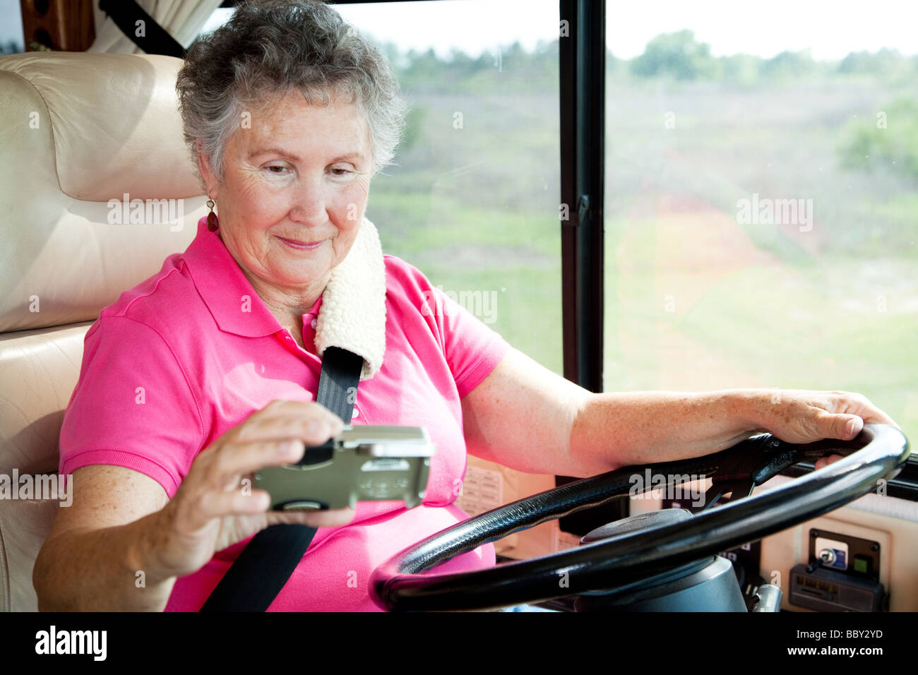 Senior woman en utilisant un GPS pour naviguer en conduisant son motor home Banque D'Images