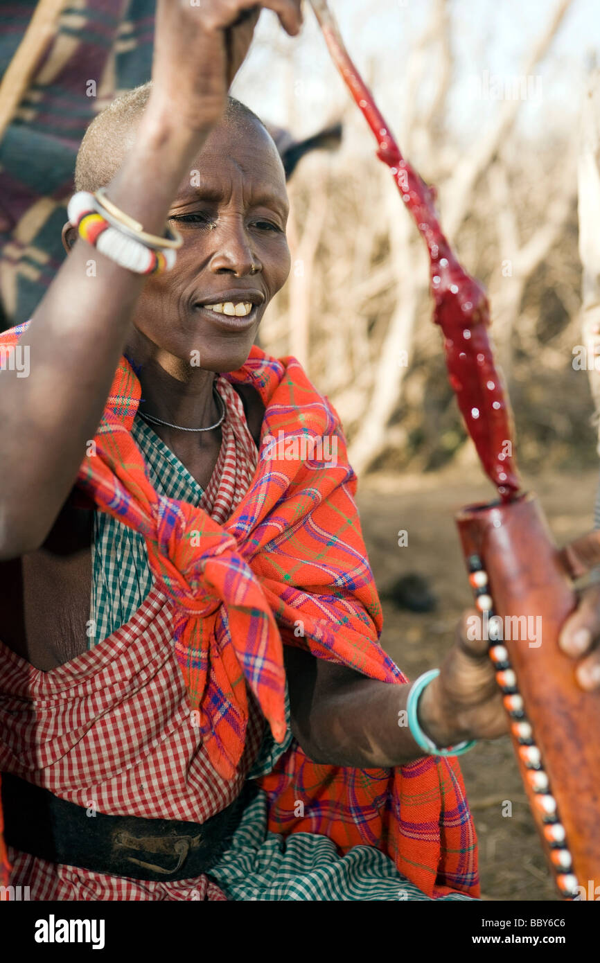 Masaï en remuant le sang de vache en calebasse - Maji Moto Village Maasai - près de Narok, Kenya Banque D'Images