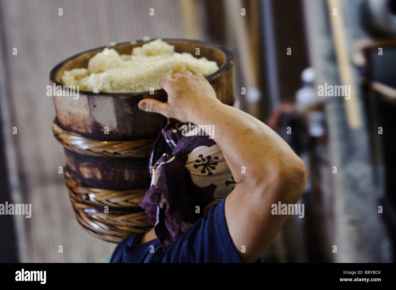 Le travailleur porte un pot de riz vapeur. Terada Honke Sake Brewery, Kozaki, Chiba, Japon, le 15 juin 2009. Banque D'Images