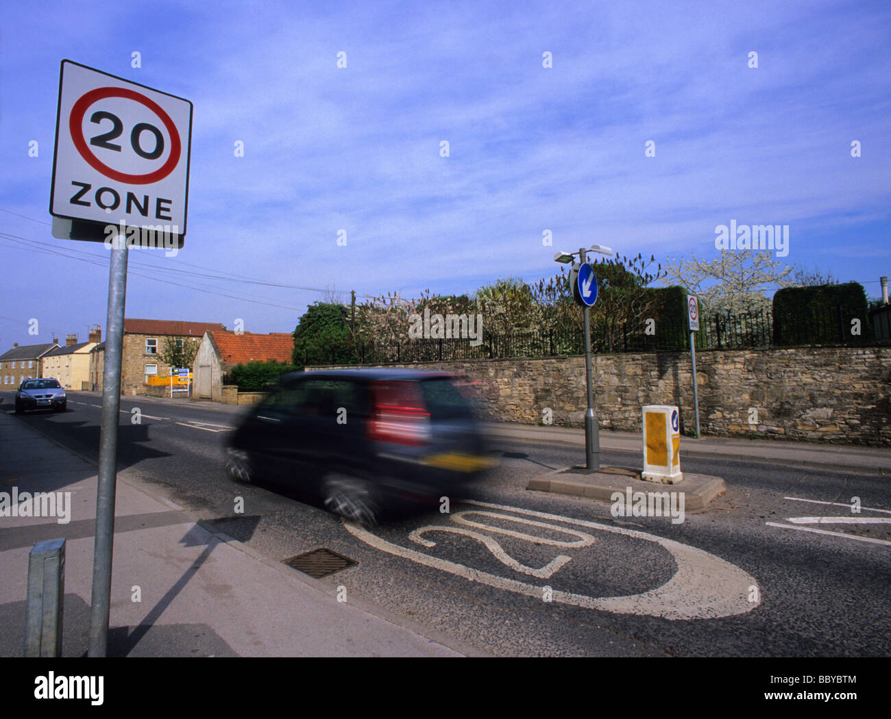 Une voiture passe 20 milles à l'heure de la zone de limite de vitesse panneau d'avertissement sur la route en passant par village près de Leeds yorkshire uk Banque D'Images