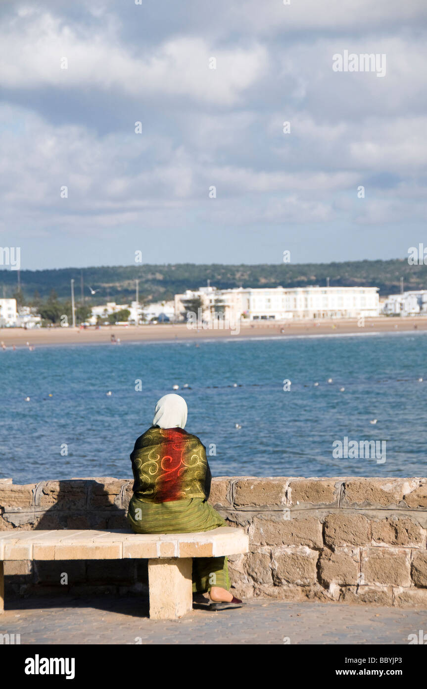 Femme musulmane en vêtements typiques avec vue sur la plage de resort ville côtière d'essaouira maroc en Afrique Banque D'Images