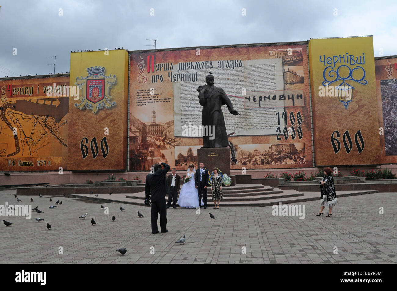 Une nouvelle couple posent pour une photo devant la Statue de Chevtchenko en place centrale, CHERNIVTSI, Ukraine. Banque D'Images