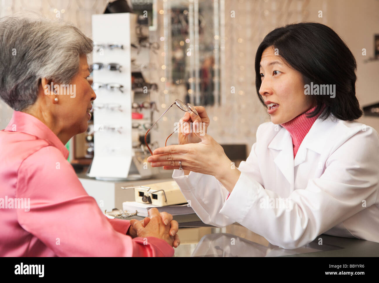 Opticien lunettes coréen montrant au client Banque D'Images