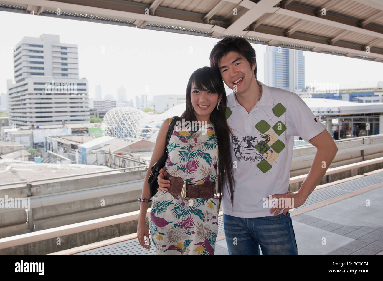 Asian couple hugging on plate-forme du métro Banque D'Images