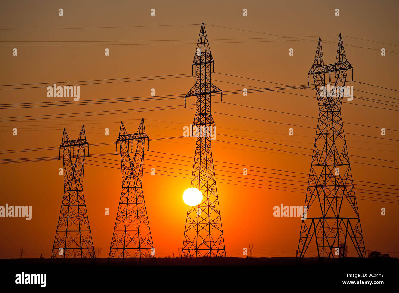 Tours de transmission d'énergie au coucher du soleil, Manitoba, Canada. Banque D'Images