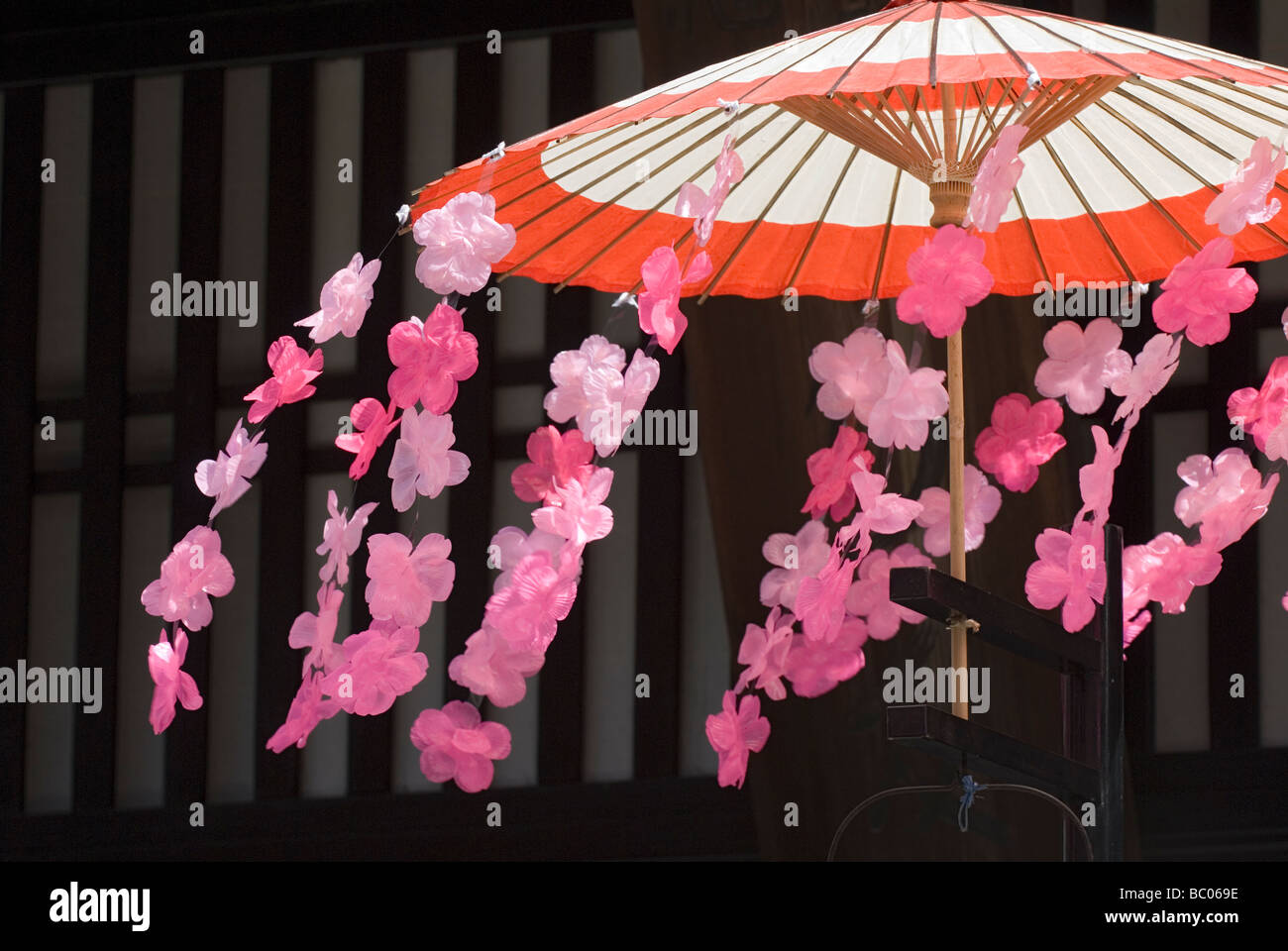 Le souffle du vent de fleurs des cerisiers en fleur en plastique qui décorent un parapluie traditionnel pendant le festival du printemps de Takayama Banque D'Images