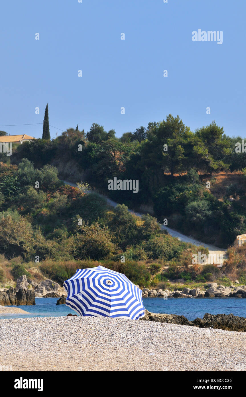 Blanc à rayures bleu parasol sur la plage Banque D'Images