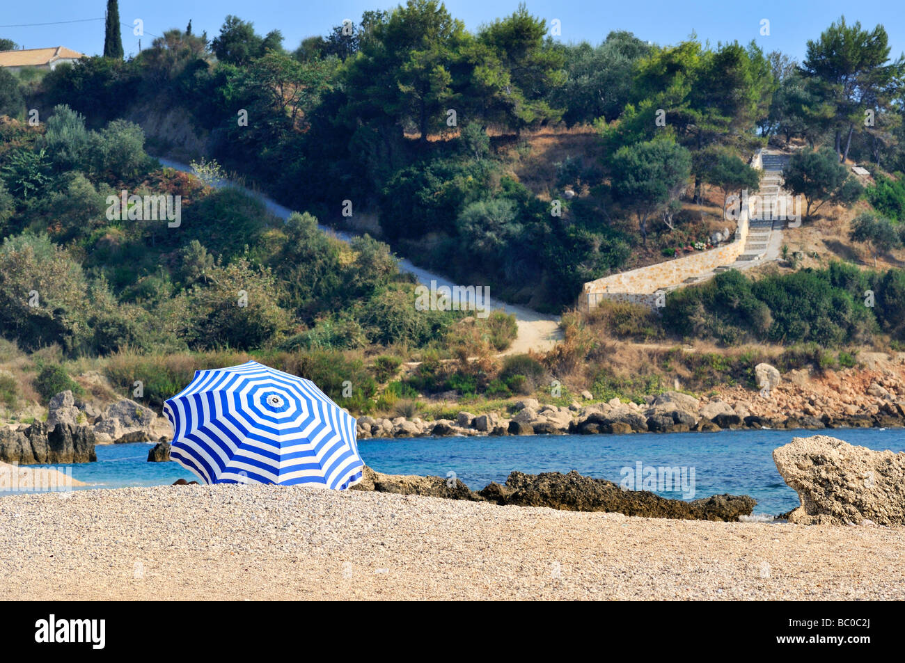 Blanc à rayures bleu parasol sur la plage Banque D'Images